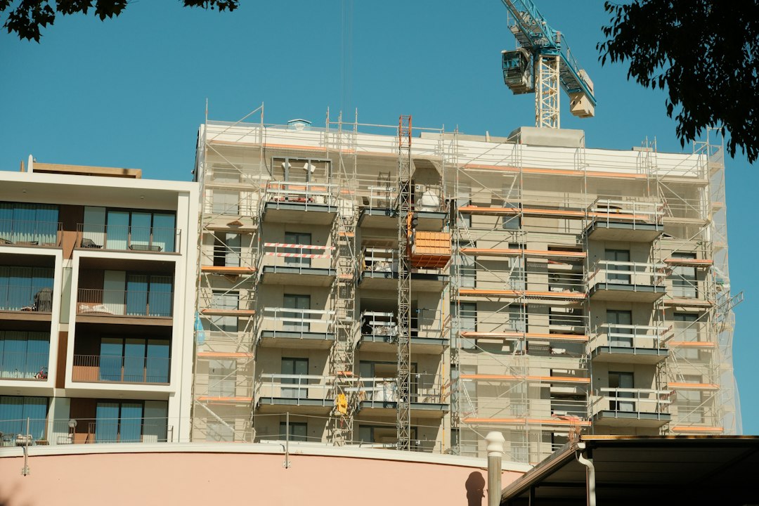 Imagem ilustrativa de prédio residencial em construção, com andaimes e guindaste